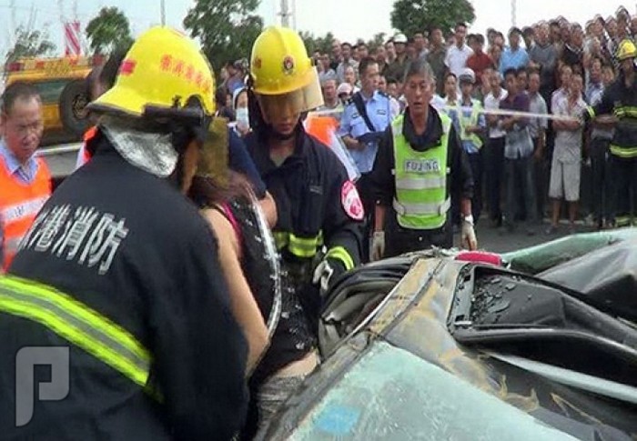 بالصور: صينية تنجو من الموت رغم سقوط حاوية نقل ضخمة على سيارتها