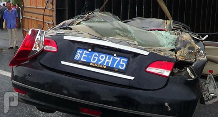 بالصور: صينية تنجو من الموت رغم سقوط حاوية نقل ضخمة على سيارتها