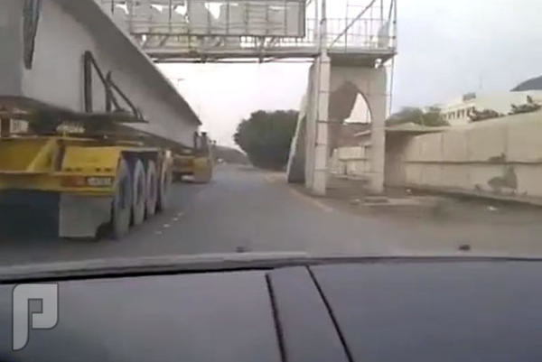 بالفيديو.. سعودي يمر بسيارته من تحت شاحنتَين!