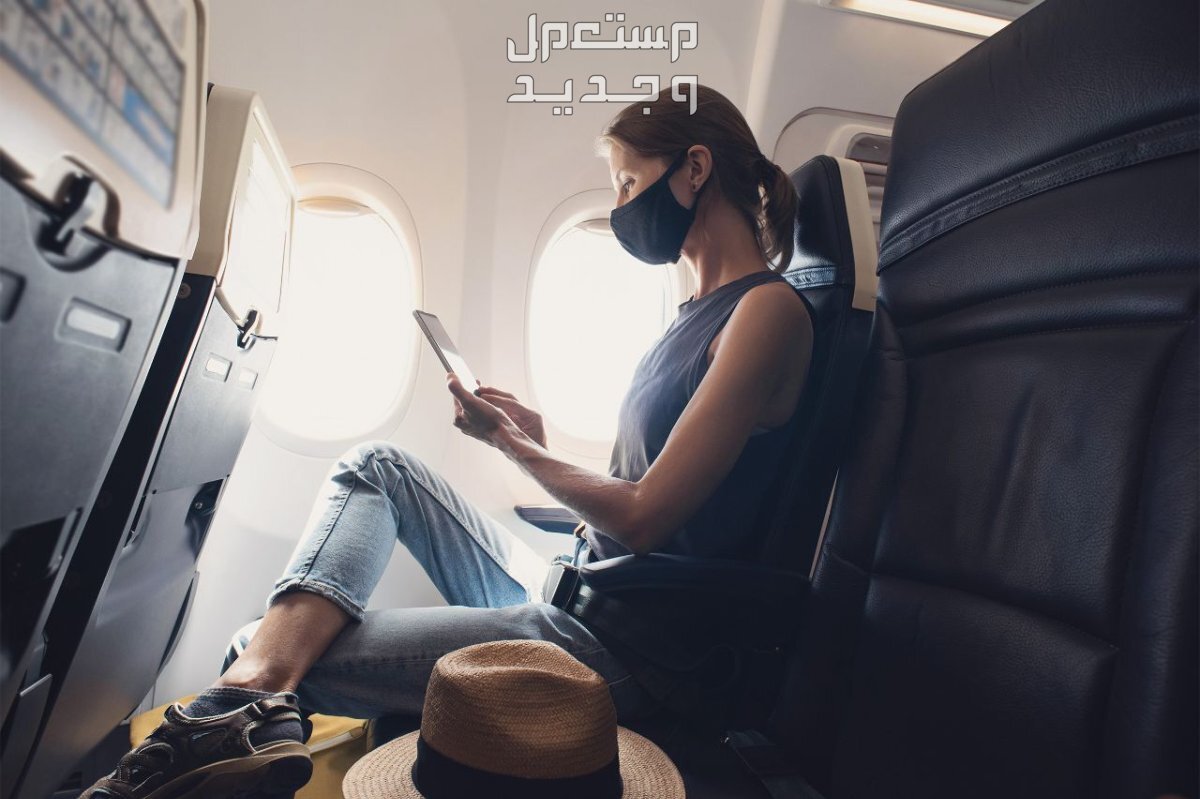ارخص تذاكر طيران يمكنك الحصول عليها بهذه الحيل سيدة تجلس في الطائرة وتمسك بالآيباد