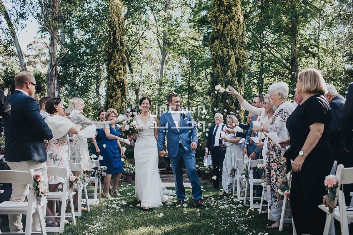 حفل زفاف نصائح للتوفير وتقليل التكاليف القاء الورود البيضاء على العروسين