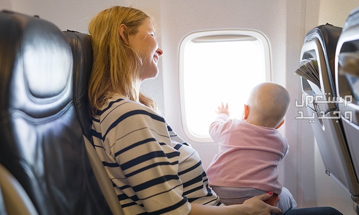 كيفية معرفة اسعار تذاكر الطيران الحقيقية دون زيادة امراة وطفلها الرضيع بجانب شباك الطائرة