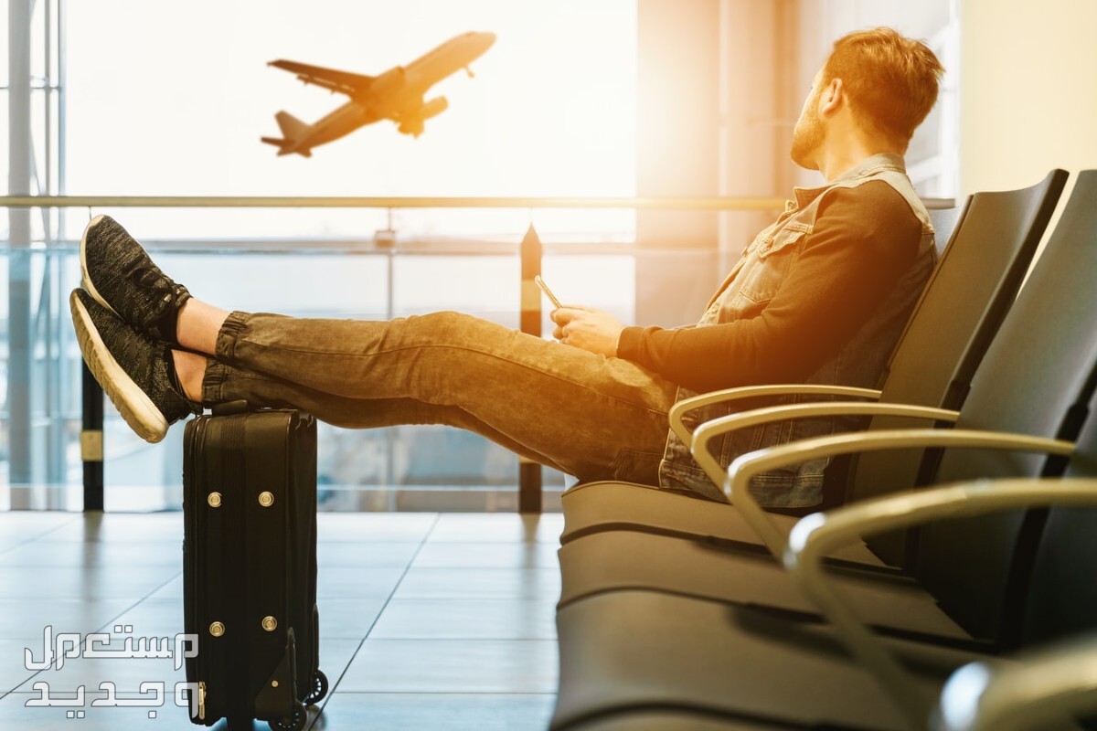 كيفية معرفة اسعار تذاكر الطيران الحقيقية دون زيادة رجل يضع قدمه على حقيبته وينظر للطائرة
