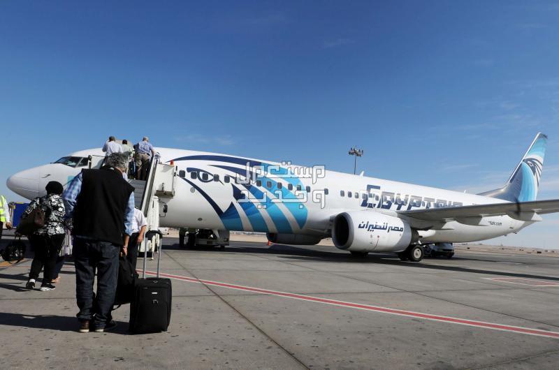 حجز تذاكر مصر للطيران وطرق الاستعلام عن الرحلات ركاب يتجهون الى طائرة مصر للطيران