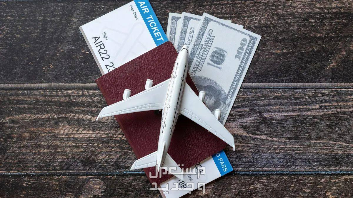 تذاكر الطيران بالاسعار الحقيقية كيف احصل عليها؟ جواز سفر فوقه مجسم صغير لطائرة وداخله تذكرة طيران ودولارات