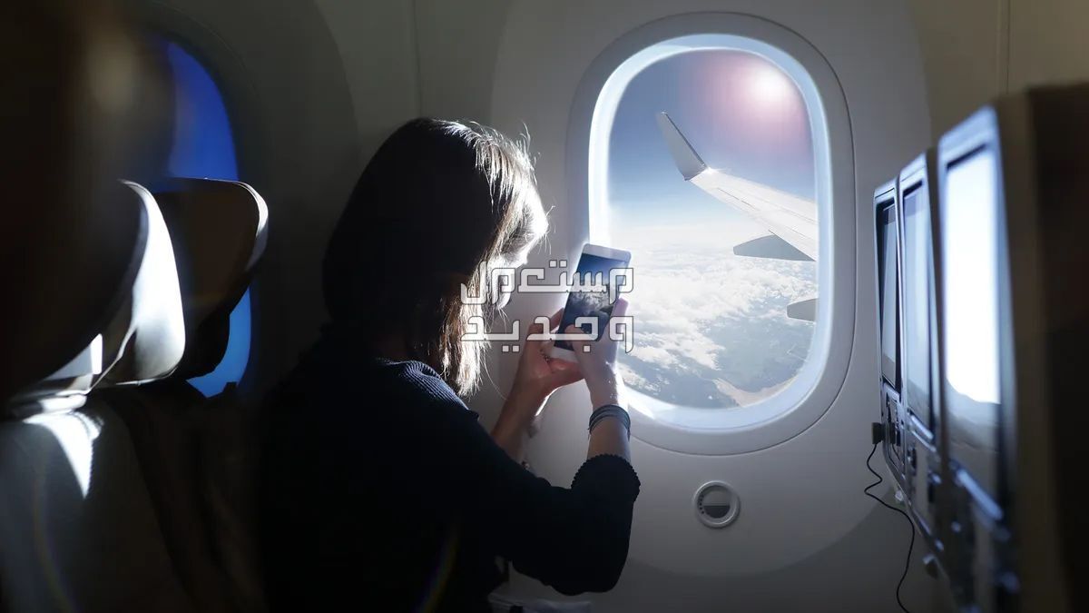 حجز تذكره سفر وكيف تختار افضل مقعد على الخطوط السعودية فتاة تجلس بجانب شباك طائرة وتصور السماء