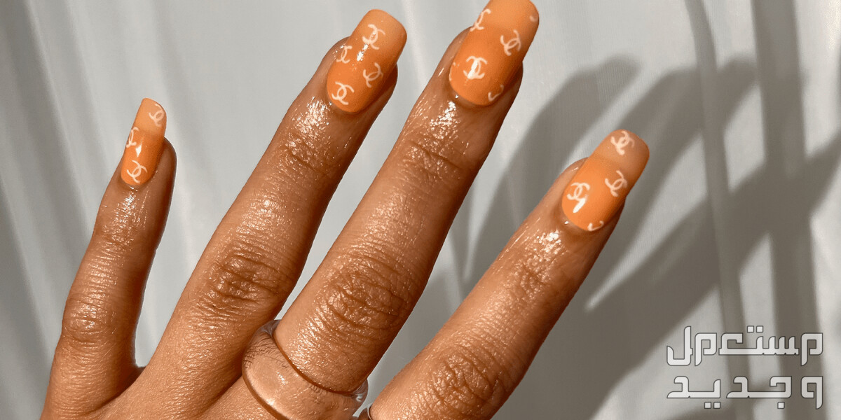 أفكار تصاميم مناكير يحمل شعار أشهر الماركات في اليَمَن تفاصيل مناكير برتقالي مزين بشعار شانيل