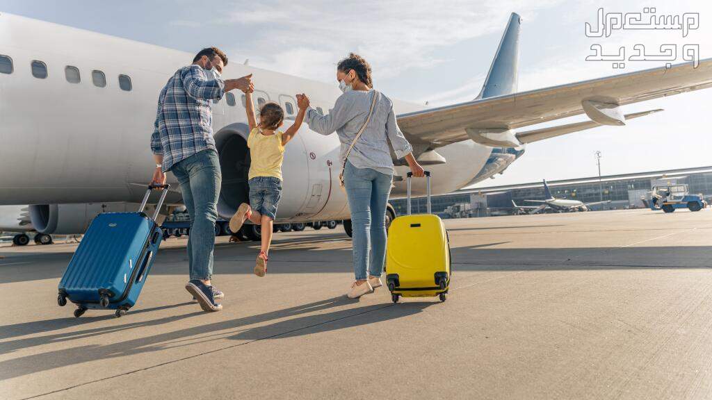 ما هو أرخص شهر لتذاكر الطيران وحجوزات السفر والرحلات؟ أب وأم يحملان طفلتهما بسعادة إلى الطائرة