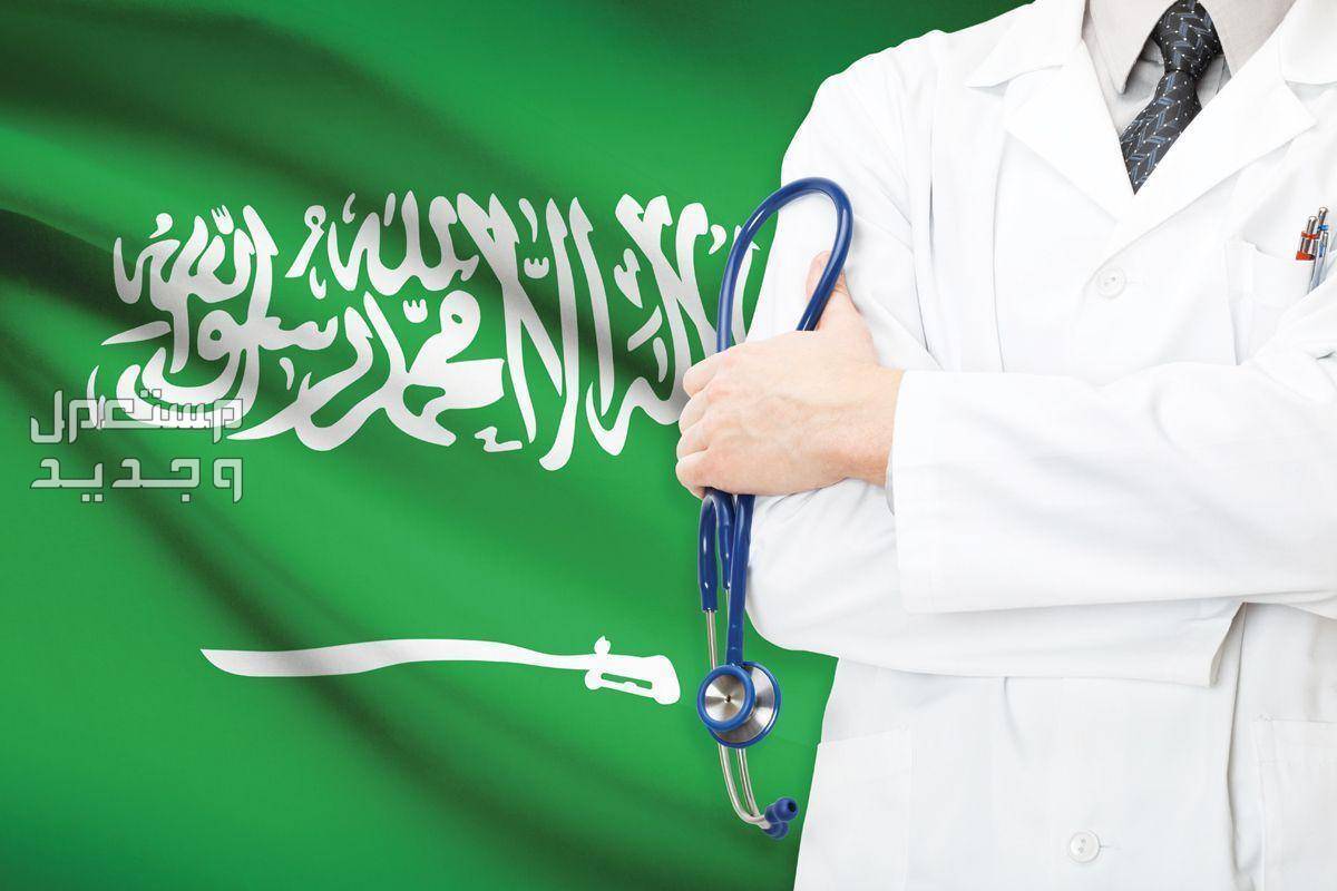 افضل وارخص شركات التامين الطبي في السعودية 2023 طبيب يمسك سماعته الطبية امام علم السعودية