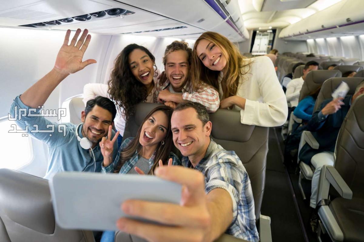 ارخص تذاكر سفر.. 8 نصائح لتوفير الكثير من الأموال اصدقاء مسافرون بالطائرة ويلتقطون الصور