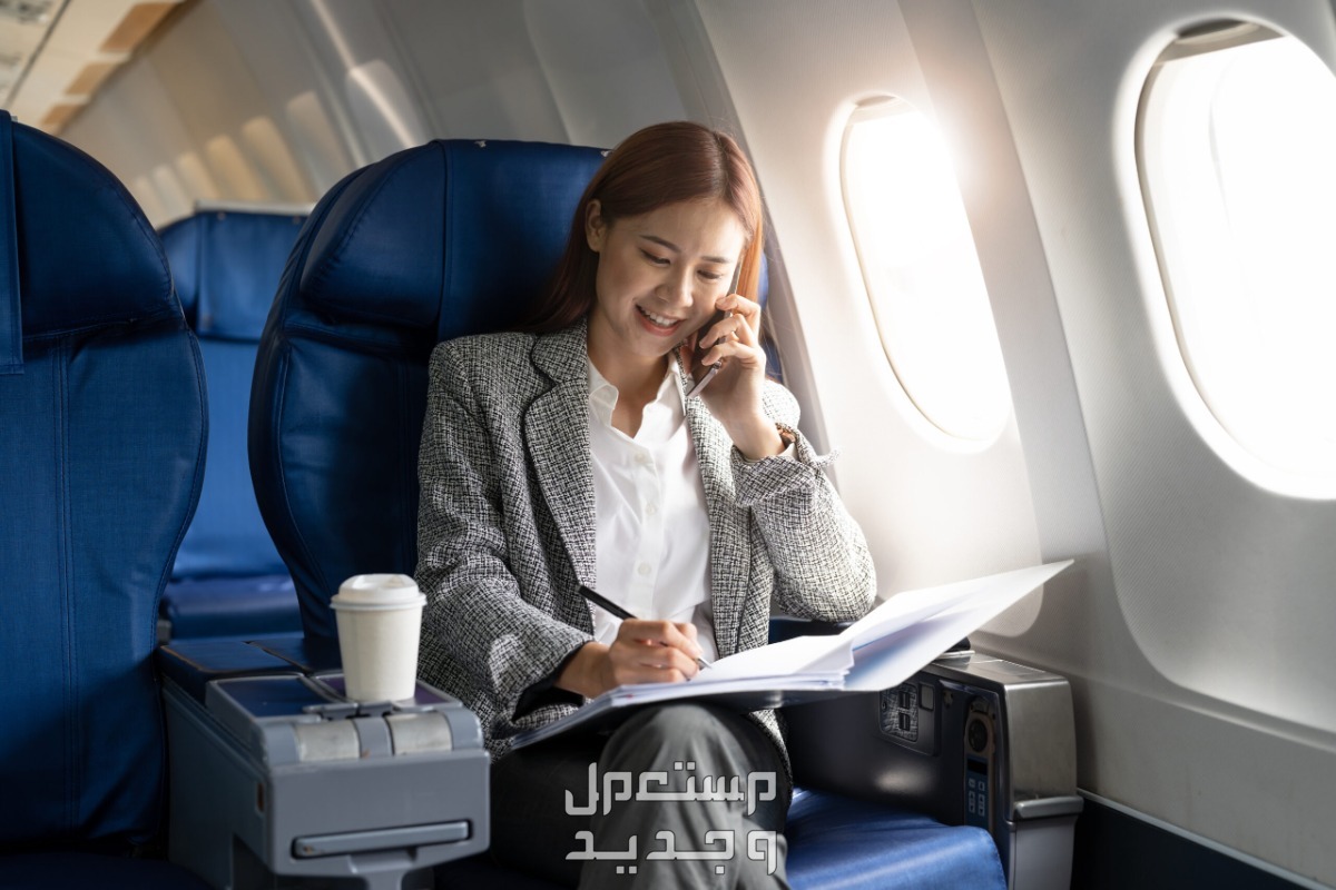 كيفية حجز تذكرة طيران اون لاين في السعودية سيدة تجلس داخل طائرة