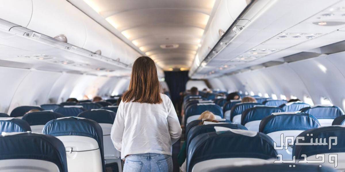ارخص موقع حجز تذاكر طيران في 2023 سيدة تسير بين مقاعد الطائرة