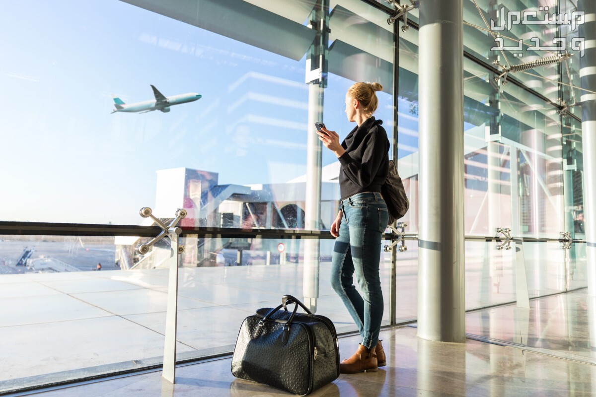 ما هو أرخص شهر لتذاكر الطيران وحجوزات السفر والرحلات؟ سيدة تنتظر الطائرة في المطار