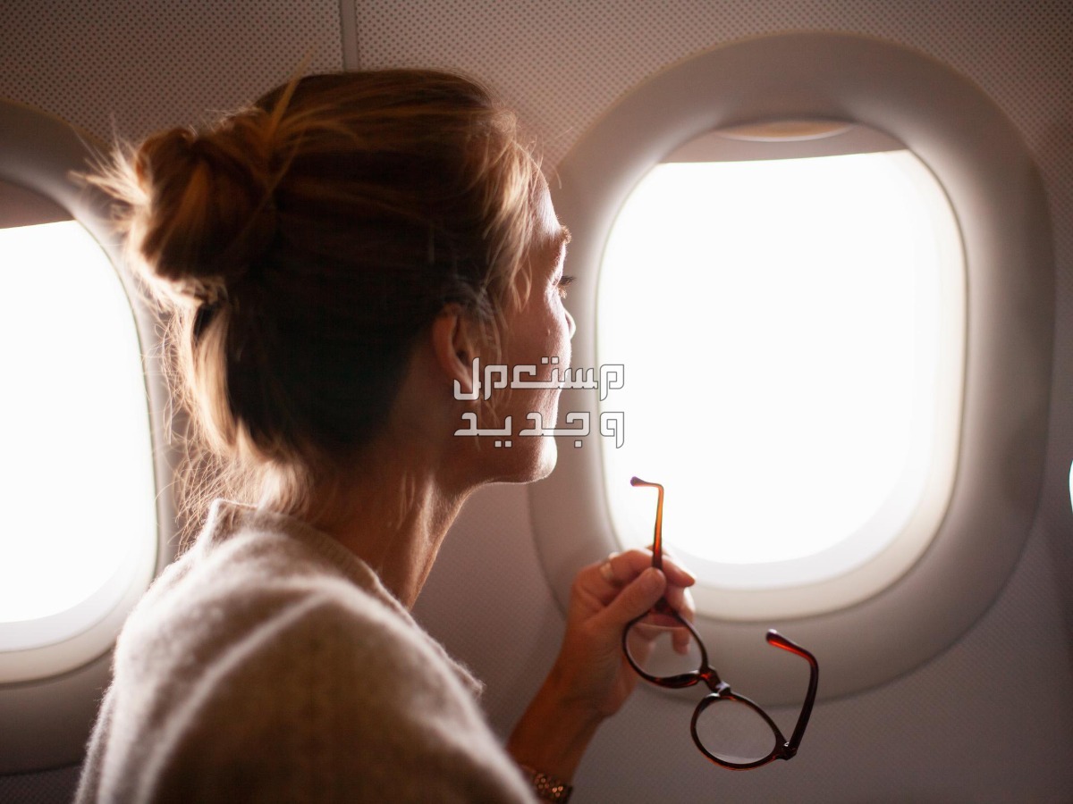 خطوات حجز تذاكر مع اشهر شركة رحلات طيران مصرية فتاة تنظر من نافذة الطائرة