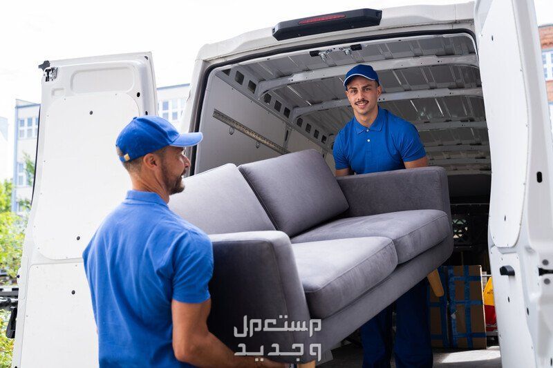افضل شركة نقل عفش في السعودية 2024 عاملان ينقلان اريكة رمادية