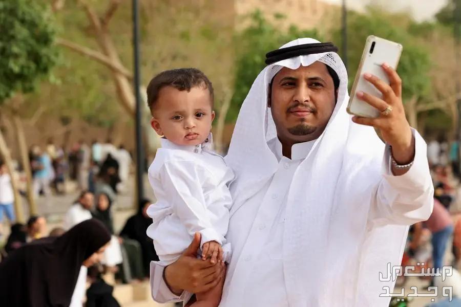 تعرف على موعد أول أيام عيد الفطر 2024 رجل يحمل طفله ويلتقط صوره