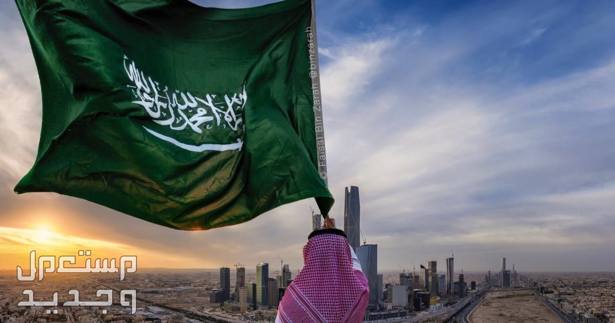 أجمل عبارات عن يوم العلم السعودي 2024 رجل يرفع العلم السعودي