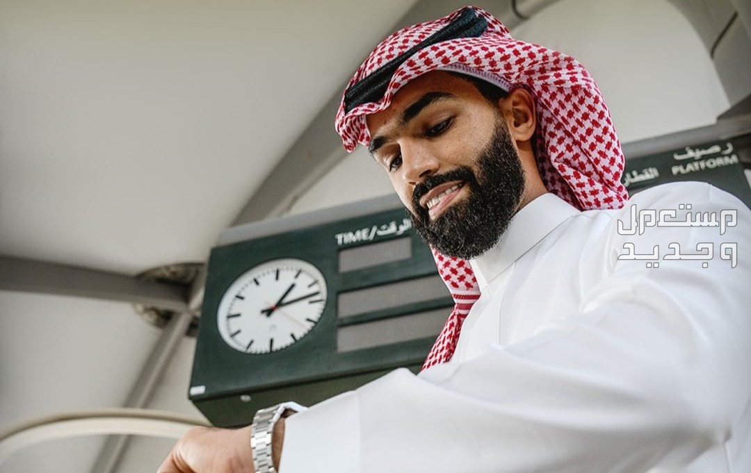 مواعيد رحلات قطار الحرمين السريع 2024 وكيفية حجز التذاكر في البحرين رجل ينظر في ساعته وينتظر قطار الحرمين