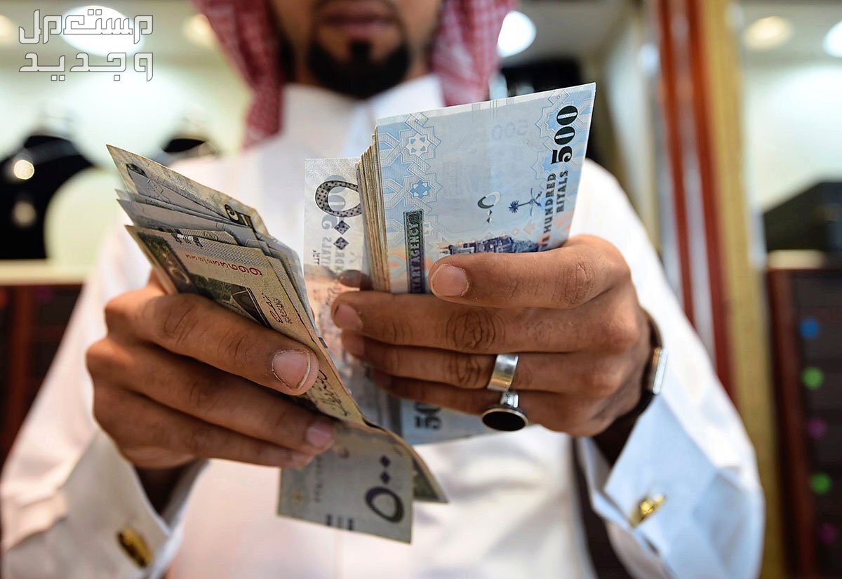 متى موعد نزول الرواتب خلال شهر رمضان 1445 رجل يمسك ريالات سعودية فئة 500