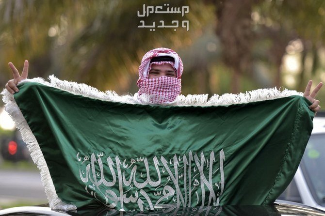 متى يوافق اليوم الوطني السعودي 94 بالهجري والميلادي في فلسطين شاب يرفع علم السعودية