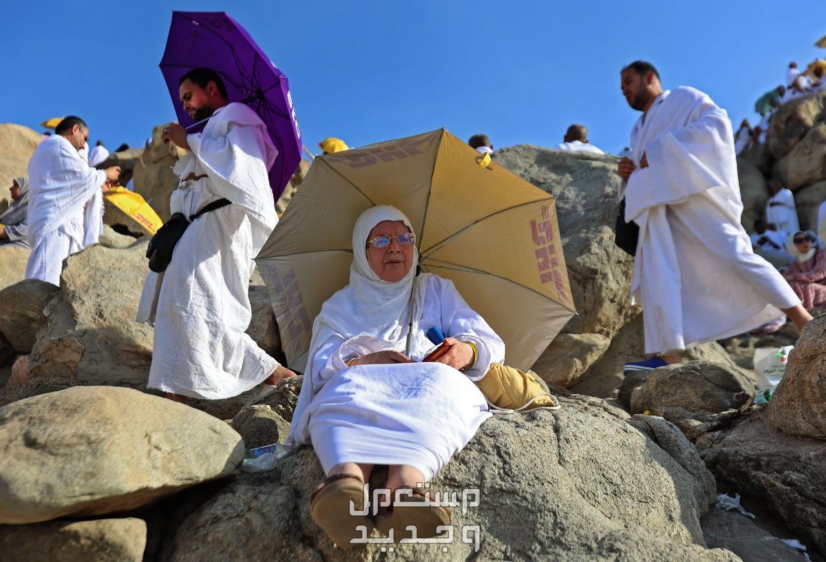 كيفية الوقاية من ضربات الشمس في الحج 1445 سيدة تستخدم مظلة وقاية من الشمس