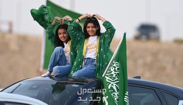 كم باقي على اليوم الوطني 94 في سوريا فتيات يحملن اعلام السعودية