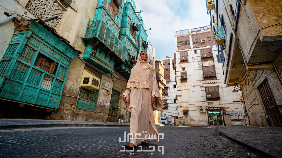 عناوين ونشاطات تستحق التجربة في جدة لعام 2024 سائحة تتنزه في منطقة البلد التاريخية في جدة