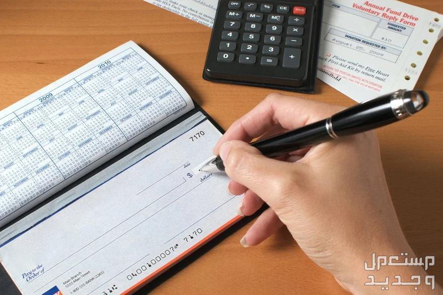 ما هو رقم سويفت كود بنك الإمارات العربية للاستثمار سيدة تكتب شيك مالي