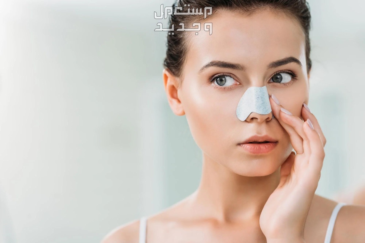 أفضل 7 منتجات تنظيف البشرة من الرؤوس السوداء سيدة تضع لاصق ازالة الرؤوس السوداء على الانف