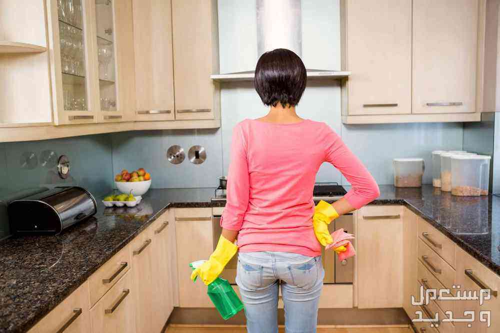 طرق التخلص من الرطوبة في خزائن المطبخ سيدة تقف في حيرة بمطبخها