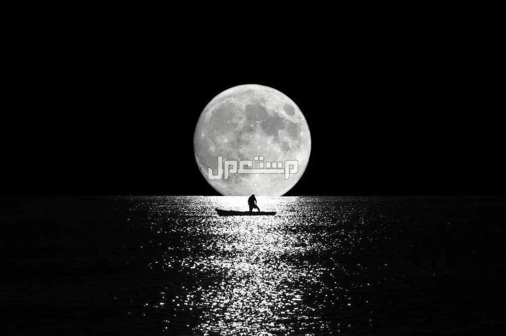 تفسير رؤية القمر في المنام للرجل والمرأة رجل يقف في قارب أمام ضوء القمر
