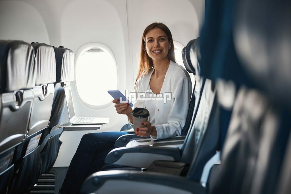 أفضل مكان للجلوس في الطائرة أثناء السفر فتاة تجلس على كرسي مريح بالطائرة