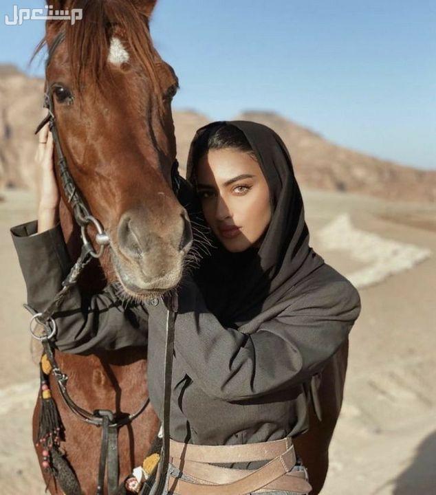 أجمل أسماء بنات بدوية خفيفة فخمة فتاة بدوية تقف الى جانب الخيل