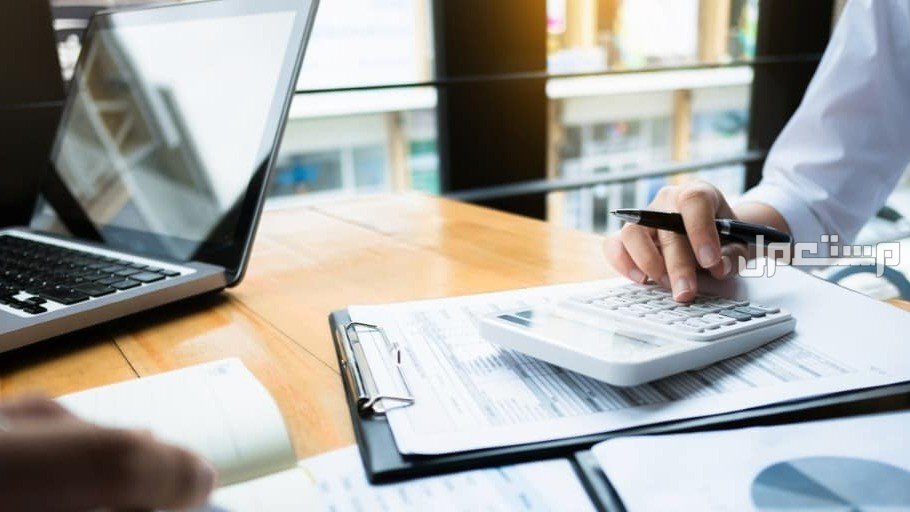 شروط التمويل العقاري 1446 دليل شامل سيدة تستخدم الالة الحاسبة لتحسب قيمة التمويل العقاري