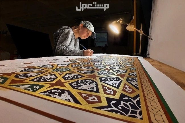 أهم مظاهر الاحتفال باليوم العالمي للفن الاسلامي 2024 سيدة تقوم برسم فن اسلامي
