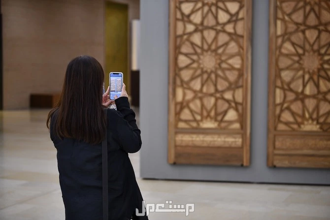 أهم مظاهر الاحتفال باليوم العالمي للفن الاسلامي 2024 فتاة تقوم يتصوير قطعة فنية اسلامية