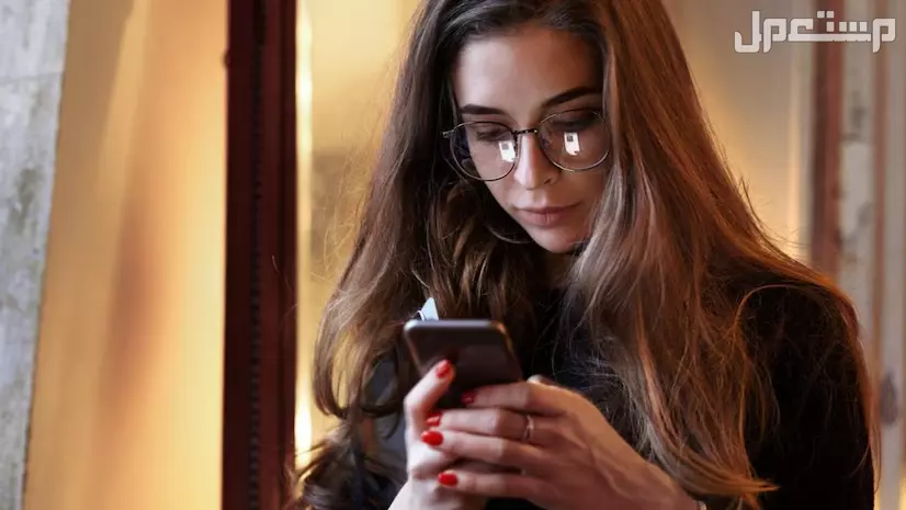 ما هو تعفن الدماغ؟ وما علاقته بالسوشال ميديا والمحتوى التافه؟ فتاة تسختدم هاتفها الجوال