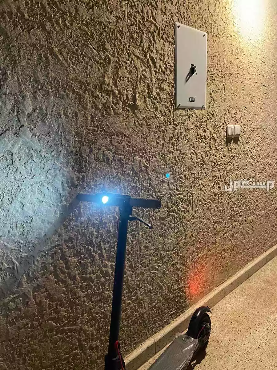 سكوتر كهربائي مع شاحن يمشي في المطر ضد الماء