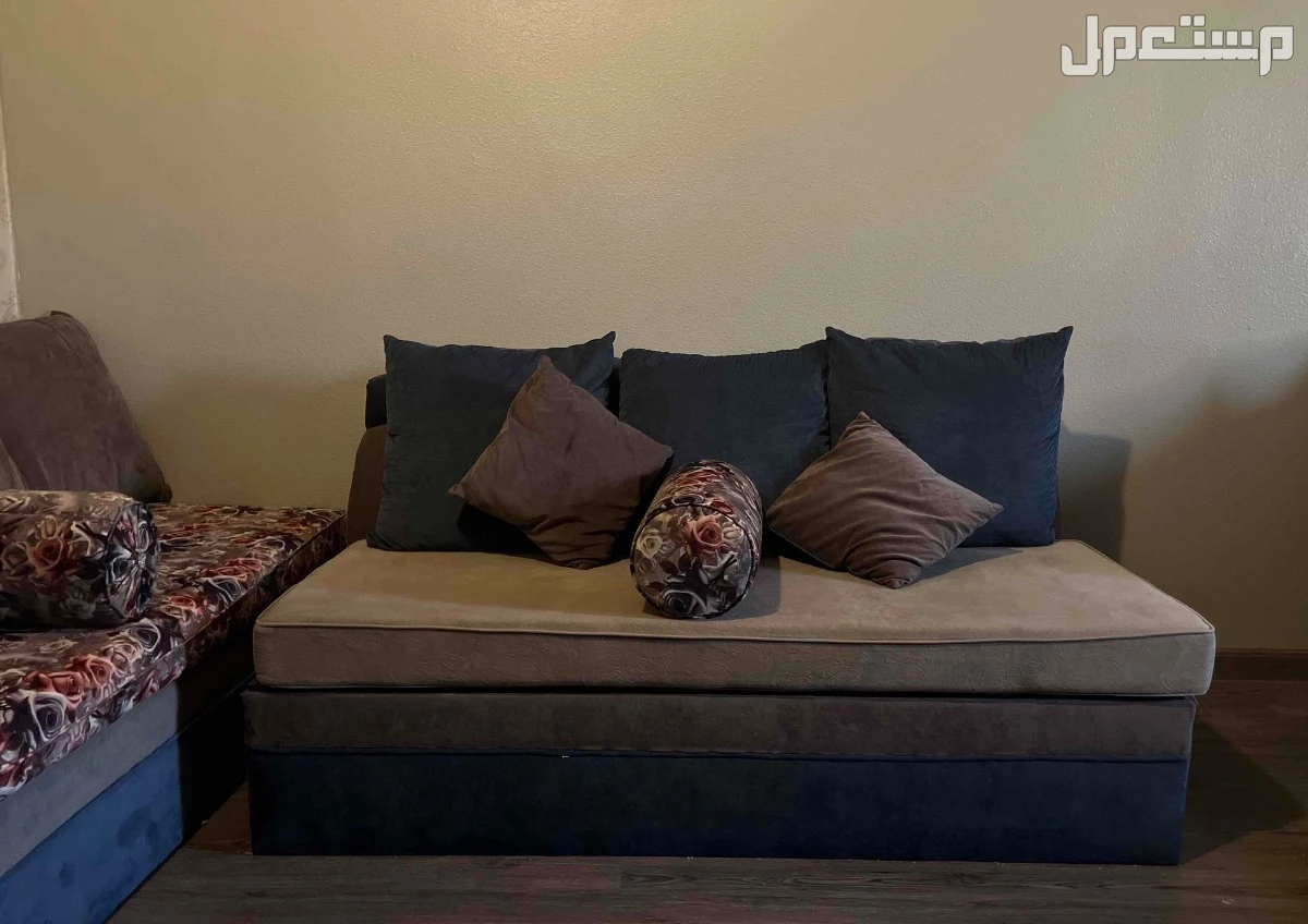 كنب ازرق ورمادي ومورد على شكل حرف L مع جهه زياده لثلاث اشخاص