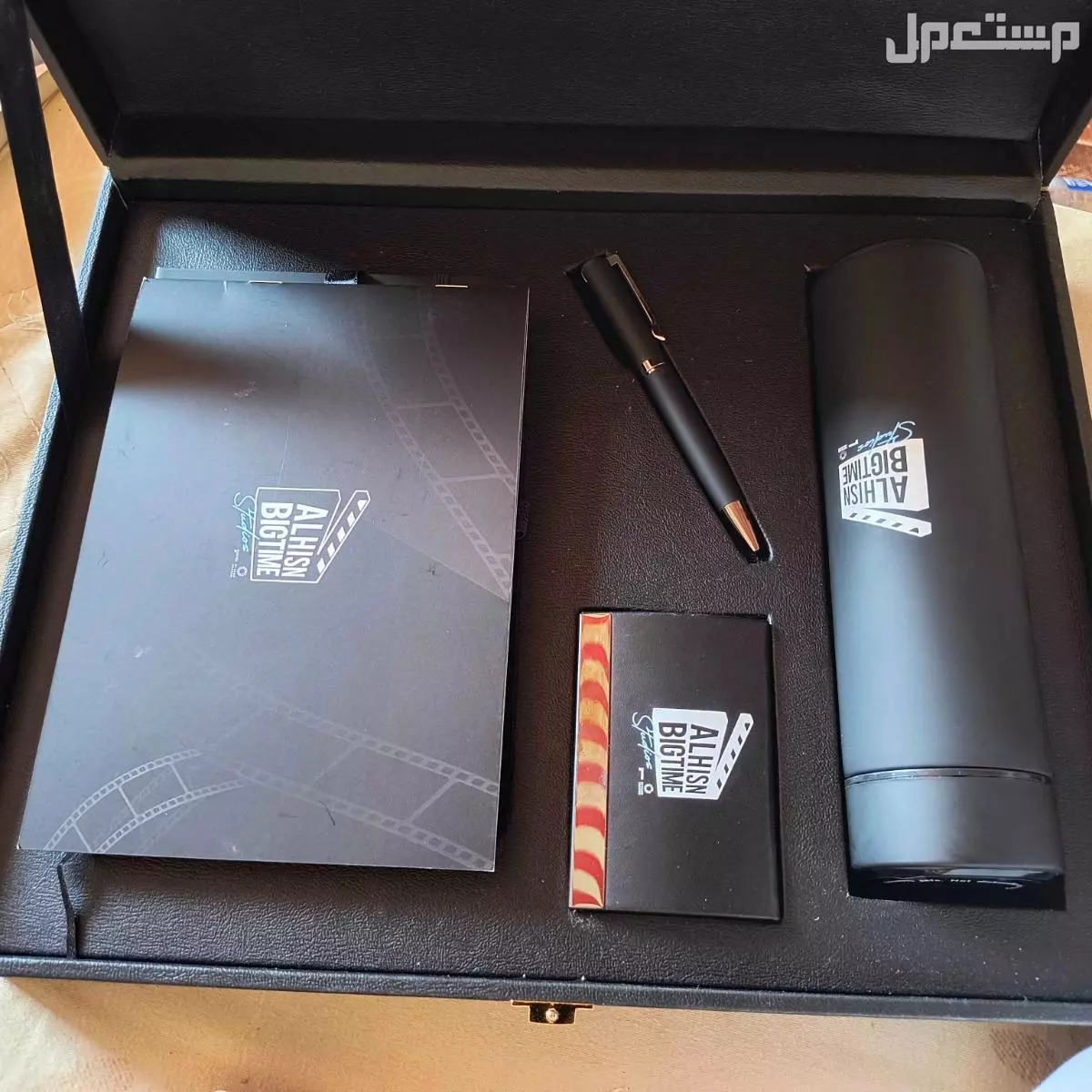 حقيبة بداخلها قلم ودفتر ملاحظات وكوب لحفظ المشروبات الحاره