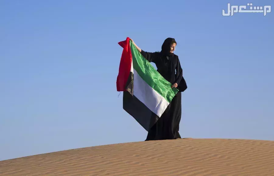 أجمل عبارات عن يوم المرأة الإماراتية 2025 بالعربي والإنجليزي (صور) سيدة ترفع العلم في يوم المرأة الإماراتية 2025